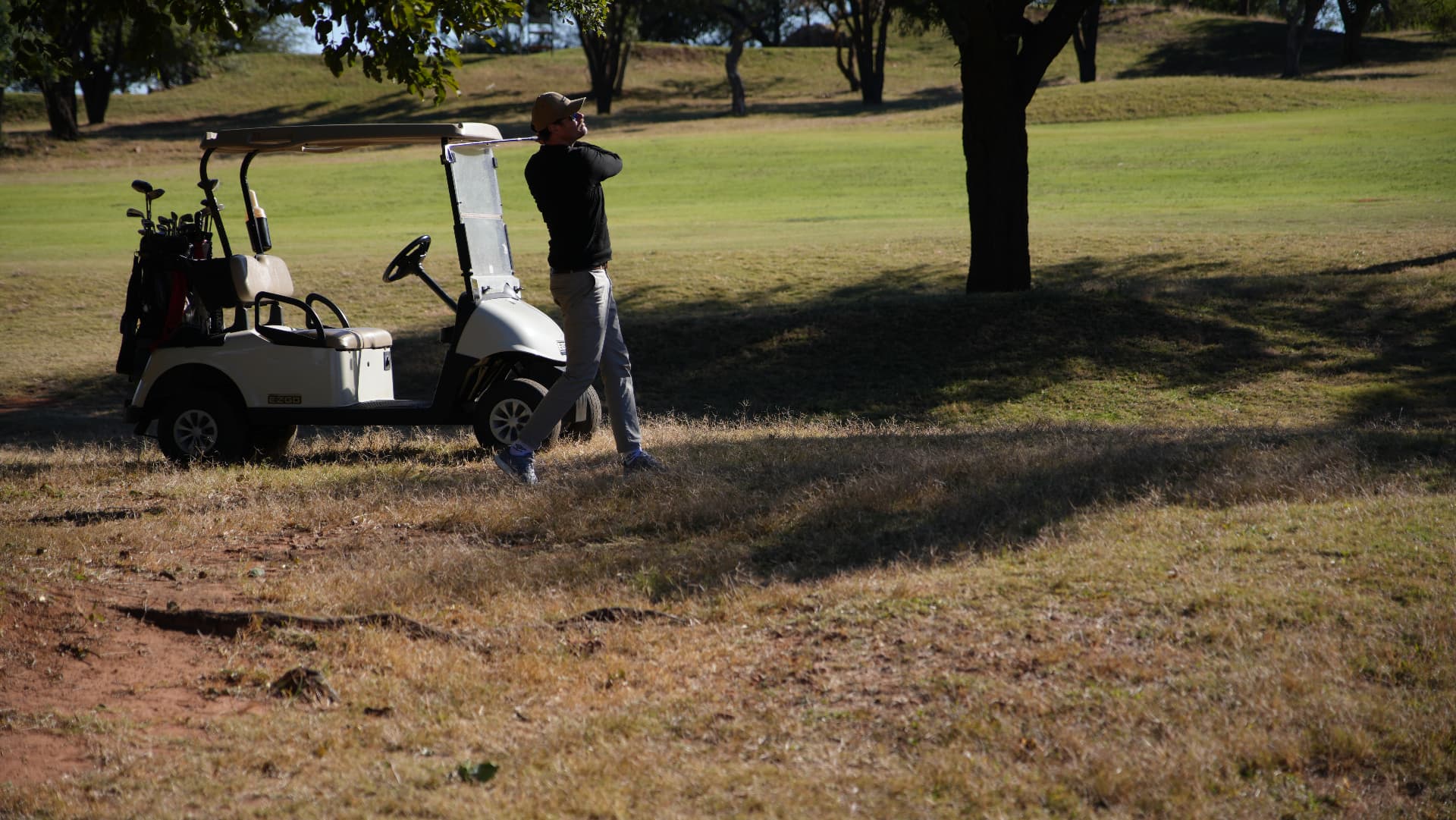 Golfer finishing a swing in golden light