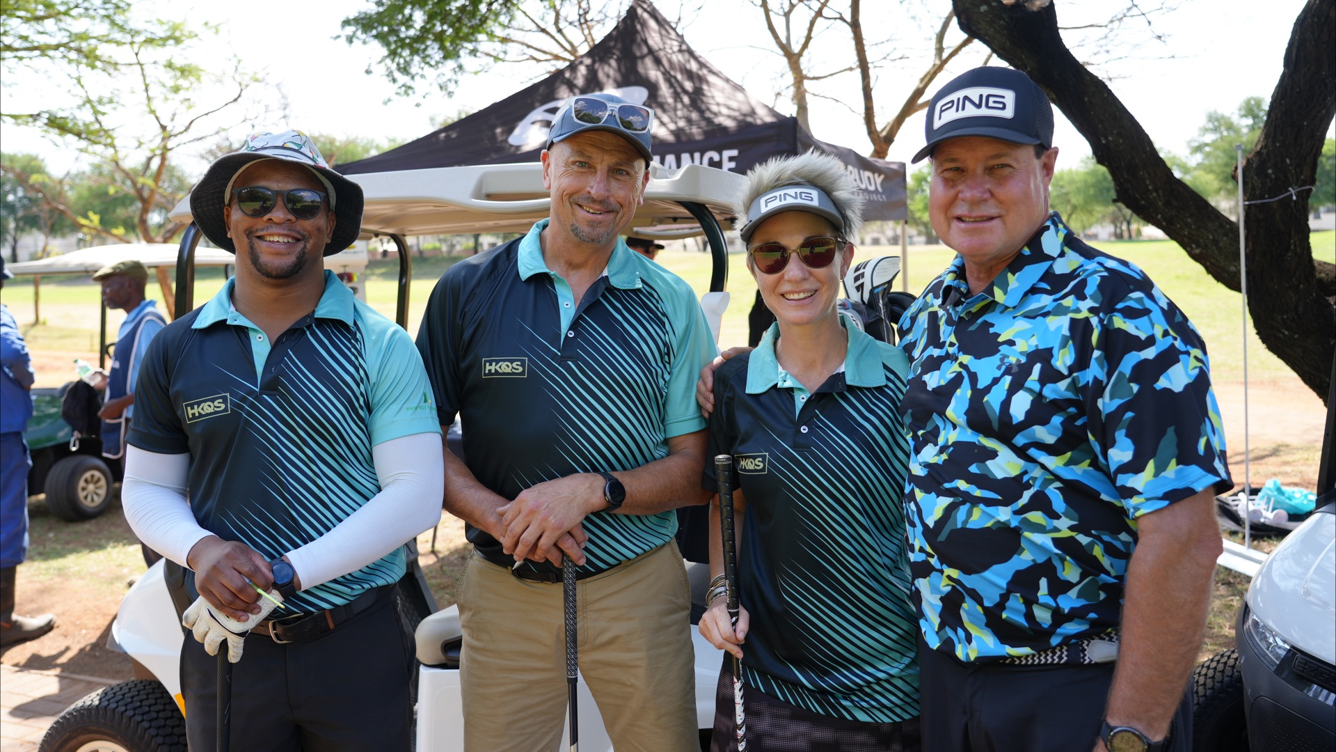Players in team shirts beside the golf cart